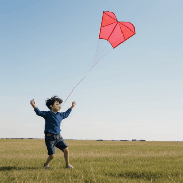 Joyful Moments: Child Flying Kite in Grassy Field