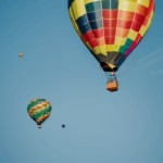 A vibrant hot air balloon soaring against the backdrop of a clear sky, epitomizing freedom and exploration.
