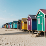 Historic beach huts in a rainbow of colors against an ocean backdrop
