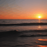 A beautiful seaside sunset with the sky painted in warm, vibrant colors.