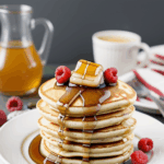 Pancakes drizzled with rich syrup and topped with a vibrant array of fresh berries, ideal for a weekend brunch.