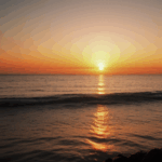 A breathtaking evening sunset casting vibrant colors over a calm ocean.