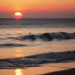 Calm evening ocean with the horizon glowing in warm, vibrant colors.
