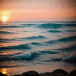Calm ocean at dusk during sunset, with the sky painted in warm hues, providing a moment of tranquility and natural beauty.