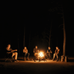 Friends exchanging stories around a bright campfire.