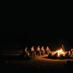 Friends bonding under the stars by a crackling campfire.