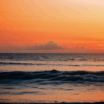 Captivating sunset hues reflecting off the tranquil ocean surface.