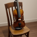 A harmonious scene of a violin on a wooden chair, ideal for artistic expression.