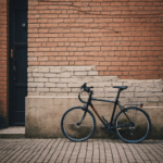 A city life moment with a bicycle against a brick wall, illustrating nostalgia and urban exploration.