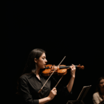 An inspiring classical music event featuring a violinist delivering a stunning live performance on stage.