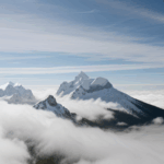 A cloud-kissed mountain peak standing majestically above the clouds, representing the thrill of high-altitude adventures.