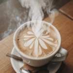 Steam rising gracefully from a freshly brewed cup of coffee on wood.