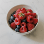 Colorful fruit bowl showcasing a mix of fresh fruits on a kitchen counter.