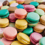Close-up shot of vibrant colorful macarons stacked, displaying a variety of vivid hues and delicious flavors.