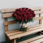 Rustic floral arrangement of roses on a bench, perfect for garden decor.