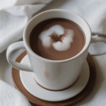 Comforting hot cocoa presented in a mug, complete with whipped cream and a dash of cinnamon for a cozy experience.