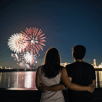 Romantic view of fireworks illuminating the night as a couple watches in awe.