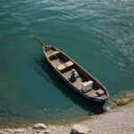 A small fishing boat glides on a serene, quiet river under a blue sky