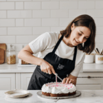 Close-up of a baker applying intricate frosting techniques to a cake.