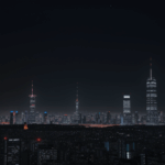 A stunning futuristic city skyline with towering skyscrapers illuminated against a starlit night sky.