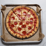 A pizza with melted cheese and a crispy crust, straight from the oven