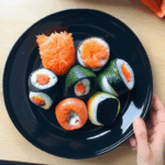 Artistic sushi rolls displayed with flair and vibrant colors.