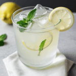Close-up of an iced lemonade with fresh mint leaves on top.