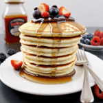 Delicious pancakes with syrup and fresh berries, creating a perfect balance of sweetness and texture.