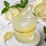 A refreshing glass of lemonade with ice and mint, perfect for summer.