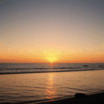 Majestic sunset waves glowing with the colors of the setting sun over the ocean.
