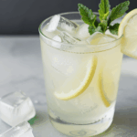 Freshly made lemonade with ice cubes and mint garnish.