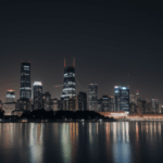 A dazzling modern city skyline illuminated at night with towering skyscrapers.