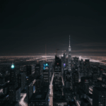 A breathtaking view of a futuristic cityscape with illuminated buildings under a clear night sky.
