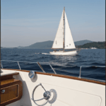 Nautical charm unfolds as a classic sailboat embarks on a tranquil journey across the calm sea.