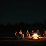 An outdoor night scene with friends enjoying a campfire.
