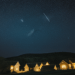 A quiet village bathed in the soft glow of a starry night, offering a peaceful retreat.