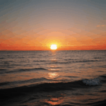 Ocean sunset glow with the sky painted in warm, vibrant hues.