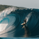 A daring surfer taking on the challenge of the ocean, riding a gigantic wave with precision.