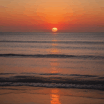 Ocean view at sunset, with the sky and sea bathed in serene, golden colors.
