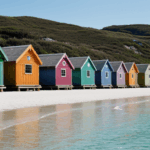 Photography of brightly colored beach huts along the coastal line