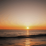Picturesque sunset over the ocean, with the horizon glowing in warm hues.