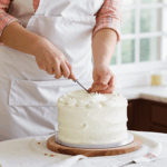 A professional baker showcasing advanced cake decorating skills.