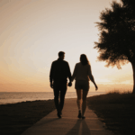 A couple walking hand in hand during a romantic sunset stroll.