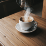 A rustic coffee setting featuring a steaming hot cup on wood.