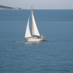 Serene sailing adventure with a classic sailboat navigating the gentle waves of the peaceful ocean.