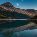 A scenic mountain sunrise with tranquil waters and a colorful sky, capturing the peaceful beauty of nature at dawn.