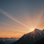 A serene mountain landscape with a stunning sunset backdrop, highlighting nature's tranquility.