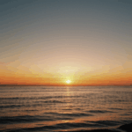 Serene sunset horizon with vibrant colors illuminating the ocean.