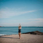 Serene yoga session by the ocean, highlighting the connection between mindfulness practice and the calming sea.