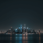 A glowing city skyline at night, with illuminated buildings that create a dramatic and enchanting urban view.